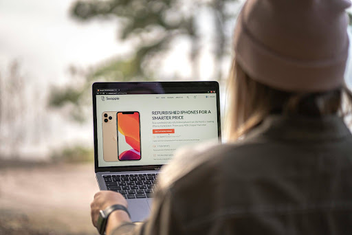 Person browsing a phone sales website on a laptop.