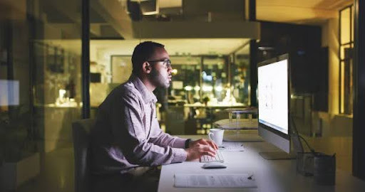 Professional waiting for a website to load on a desktop.