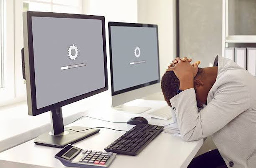 Person frustrated by slow website load on a desktop computer.